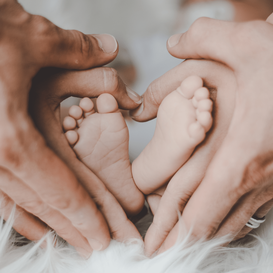 mains parents autour de pieds bébé
